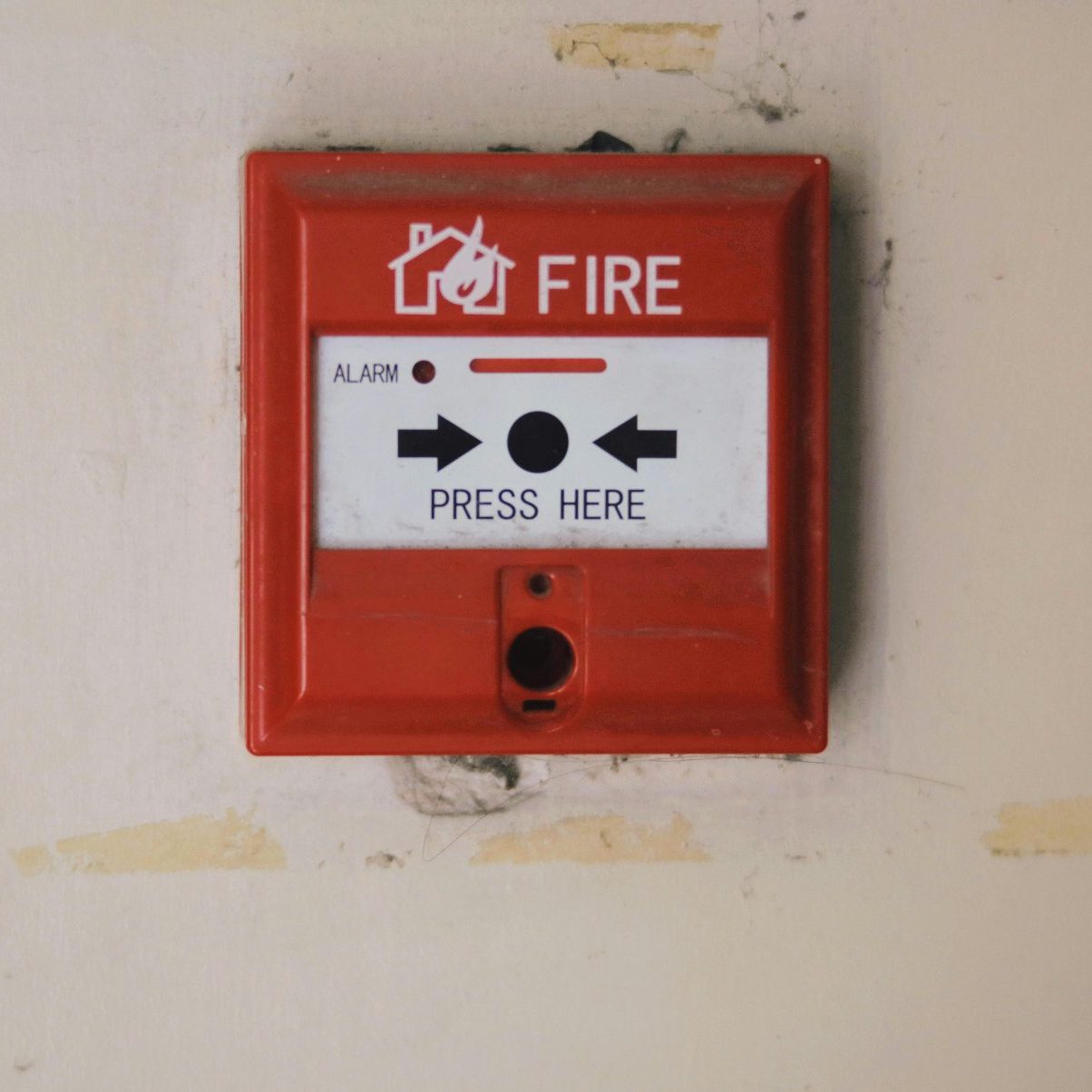 Emergency safety fire detection system box for safety with inscription and push button placed on white wall in light room