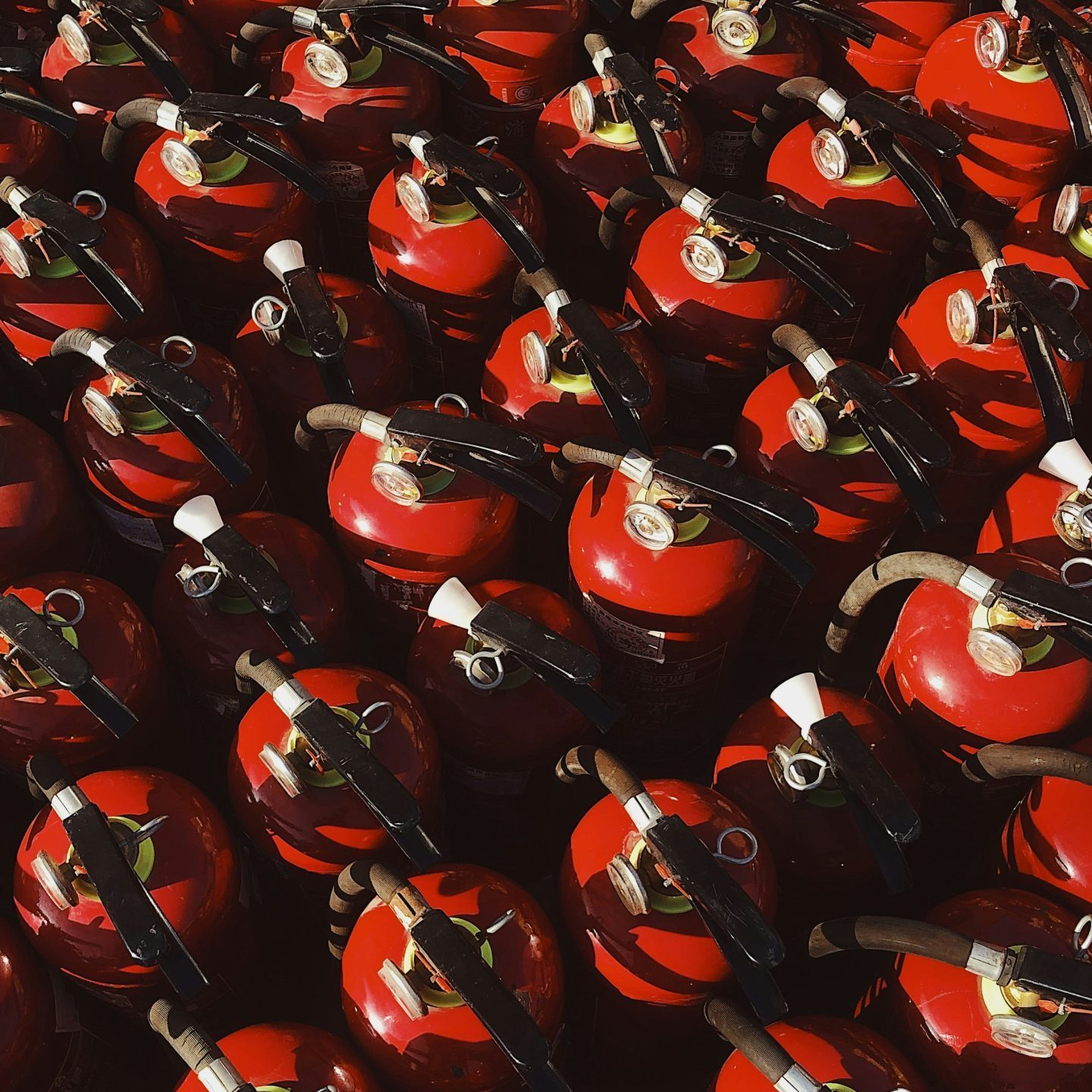 red and black ceramic mugs on black steel rack