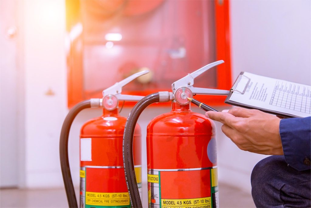 Técnico revisa dos extintores